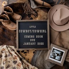 a cowboy themed baby announcement surrounded by hats, blankets and other things to put on it