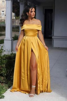 a woman in a yellow dress posing for the camera