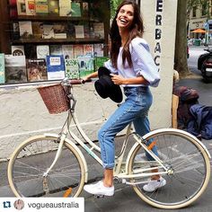 a woman riding on the back of a white bike