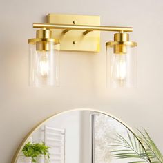 a bathroom vanity light with two lights on it and a mirror in front of it