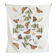 a white wall hanging with orange butterflies on it