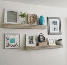 three wooden shelves with pictures and frames on them