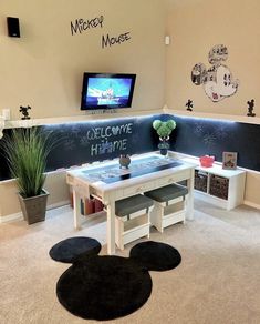 a room with mickey mouse decorations on the wall and chalkboard writing on the walls