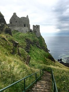 the stairs lead up to an old castle on top of a hill by the ocean