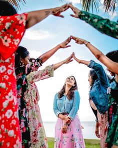 a group of women standing next to each other holding their hands up in the air