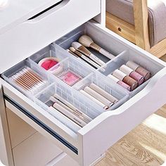 an open drawer with makeup and brushes in it