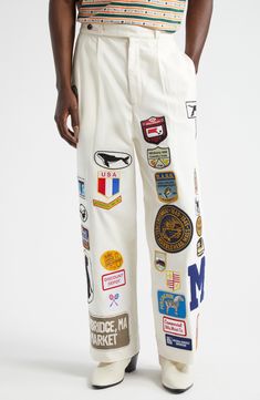 Classic workwear from the '40s and '50s serves as the model for these cotton-canvas pants detailed all over with vintage and reproduction-vintage patches. 29" inseam; 22" leg opening; 15" front rise; 17 1/2" back rise (size 34) Zip fly with button-tab closure Side-seam pockets; back welt pockets 100% cotton Dry clean Imported Designer Clothing Iron On Patches Pants, Patches Aesthetic Clothes, Patches On Denim, Pants With Patches, Senior Pants, Unisex Clothing Fashion, Patch Clothes, Denim Diy Clothes, Patches On Clothes