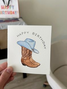 a person holding up a card with a cowboy boot on it and the words happy birthday