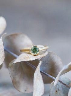 The round bicolor green sapphire was mined in the Songea, Tanzania, and hasn't been heated or treated. The 18 karat yellow gold band brings out the sapphire's warmer tones and magnifies its gorgeous gleams. Each piece of our jewelry is handcrafted with love. Everyday Yellow Gold Solitaire Emerald Ring, Gold Sapphire Ring With Smooth Bezel, Timeless Green Sapphire Ring For Anniversary, Green Sapphire Round Ring, Fine Jewelry 14k Gold Green Sapphire Ring, Timeless Gold Round Emerald Ring, Timeless Emerald Ring In Yellow Gold, Gold Yellow Sapphire Round Ring, Gold Round Yellow Sapphire Ring