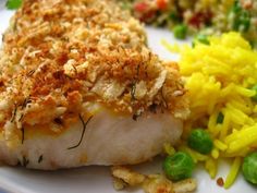 a white plate topped with meat and veggies next to breaded crumbs