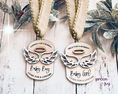 two wooden tags with angel wings and the words, baby boy or girl printed on them