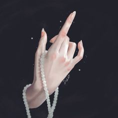 a woman's hand with pearls on her wrist