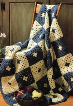 a crocheted blanket sitting on top of a wooden chair