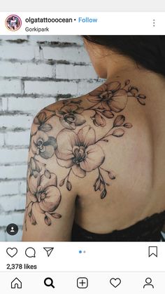 the back of a woman's shoulder with flowers on it