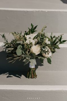 a bridal bouquet sitting on the steps