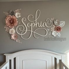 a white crib with flowers on it and the word sohna spelled in cursive