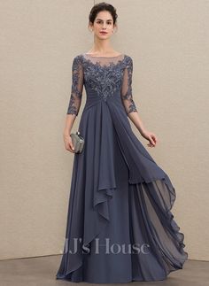 a woman in a long gray dress with sheer sleeves and lace on the top, wearing a