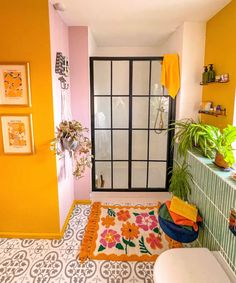 a bathroom with yellow walls and tiled flooring, potted plants in the corner