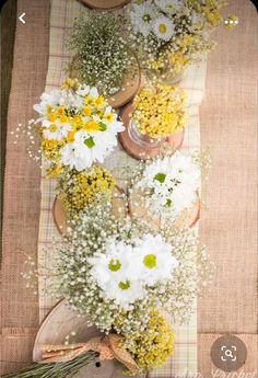 flowers are arranged in vases on a tablecloth with a brown and white checkered cloth