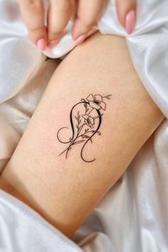 a woman's leg with a tattoo on it that has flowers in the shape of a heart