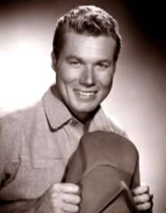 a black and white photo of a man holding a hat