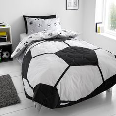 a soccer ball comforter set on a bed in a room with white flooring