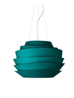 a green light hanging from a ceiling fixture with three lights on each side and four different shades of teal