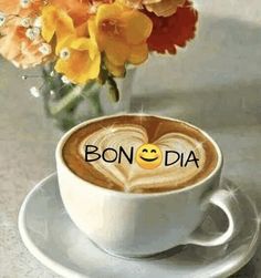 there is a cup of coffee with the word bon - dia in front of it