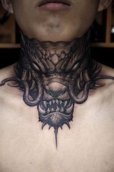 a close up of a man's neck with an elaborate tattoo on it