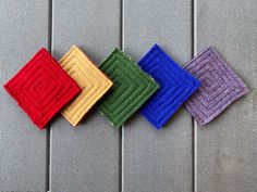 four different colored napkins sitting on top of a gray table next to each other