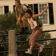 two people are riding skateboards on a rail