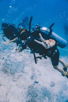 two scuba divers with their equipment in the water