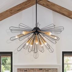 a large chandelier hanging from the ceiling in a living room with brick fireplace