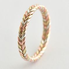 a gold and silver braid ring on a white background with the word love written in it