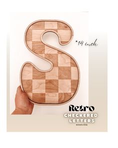 the letter s is made out of wood and has a checkered pattern on it