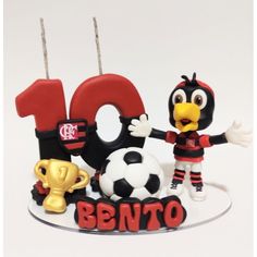 a birthday cake with the number ten on it and an animal figure holding a soccer ball