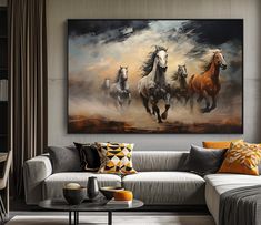 three horses running through the air in front of a painting hanging on a wall above a couch