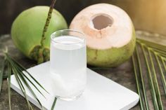 a glass of water next to some coconuts