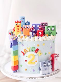 a birthday cake decorated with lots of colorful toys and numbers on the top, sitting on a white plate