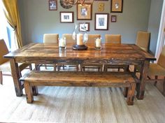 a dining room table with two benches and pictures on the wall