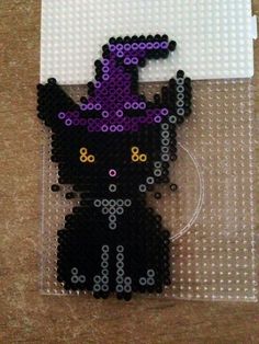 a black cat with purple and yellow eyes is made out of legos