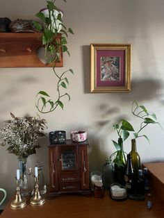 a wooden table topped with vases filled with flowers and bottles on top of it