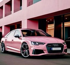 a pink car parked in front of a building