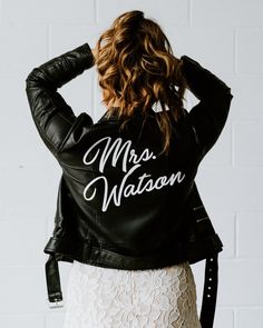 a woman wearing a black leather jacket with the word mrs watson written on it in white