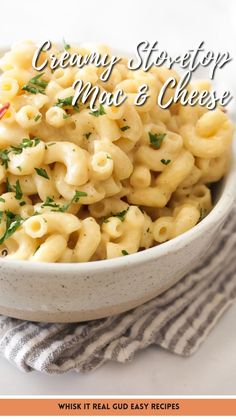 a white bowl filled with macaroni and cheese on top of a striped towel