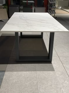 a white marble table sitting on top of a tile floor