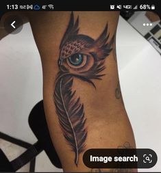 an owl with blue eyes and a feather tattoo on the leg is seen in this image