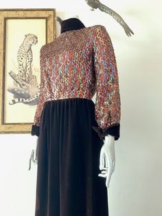 "Amazing 1970s red carpet gown! The sparkly, sequined bodice in the centerpiece to a classic brown velvet rolled high collar, long cuffed sleeve, and straight maxi skirt. Iridescent sequins sewn in vertical wavy design on bodice. High rolled collar with points down the back. Cuffs mirror the collar design. Velvet spine detail with back zip. Hook/eye closures at back neck. Snap closures on cuffs. Bodice is lined with netting. Skirt is lined with with satin. Labelled vintage size 8, but please com Formal Sequined Maxi Dress For Fall, Glamorous Sequin Maxi Dress For Fall, Fall Sequin Long Sleeve Maxi Dress, Glamorous Fall Sequined Maxi Dress, Embellished Maxi Dress For Fall, Embellished Fall Maxi Dress, Brown Maxi Dress For Evening In Fall, Brown Maxi Dress For Fall Evening, Retro Evening Dress For Fall