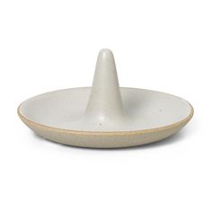 a white plate with a small cone on the top and a brown rim around it