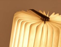 an open book shaped like a lamp with a black pen sticking out of it's middle